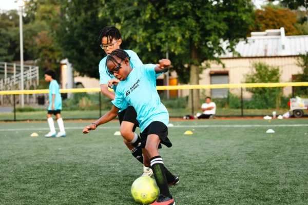Two young athletes stay active in an Asphalt Green Soccer Club program.