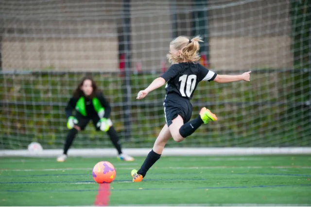 An Asphalt Green Soccer Club player lines up for a shot on goal.