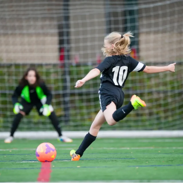 An Asphalt Green Soccer Club player lines up for a shot on goal.