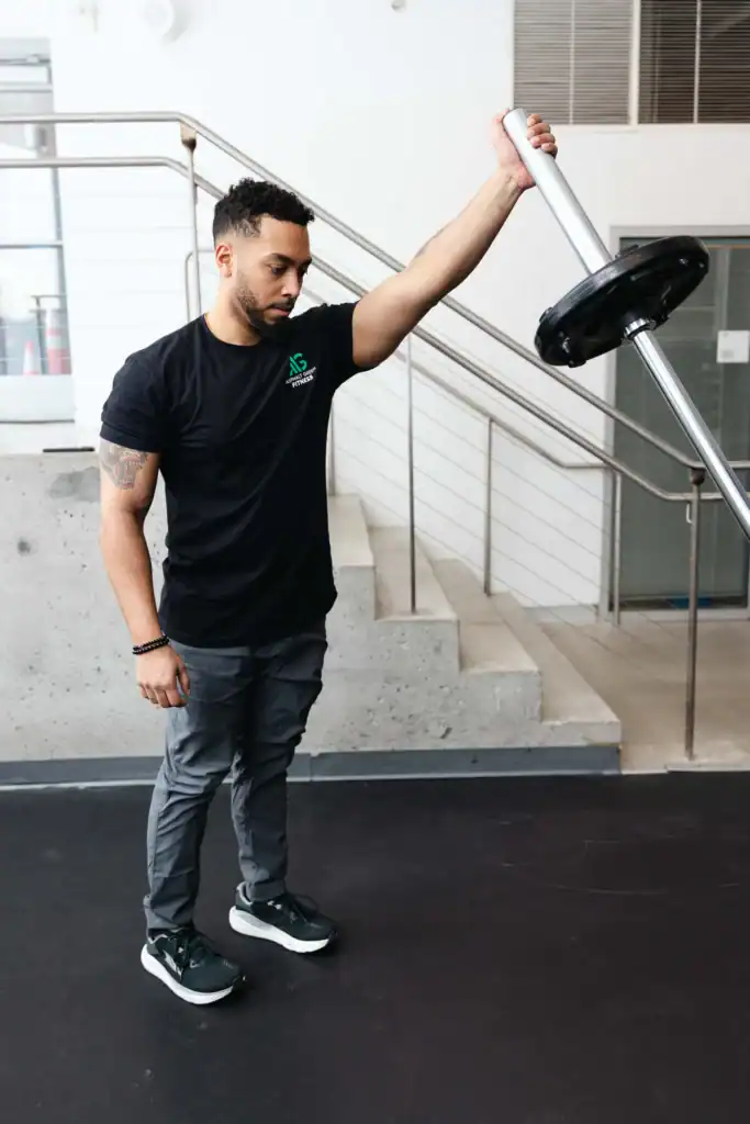 AG Fitness trainer performs the landmine reverse lunge to press exercise.