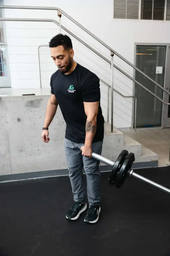 AG Fitness trainer performs the landmine single-leg deadlift exercise.