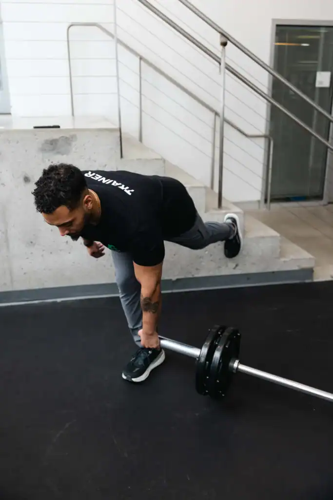 AG Fitness trainer performs the landmine single-leg deadlift exercise.