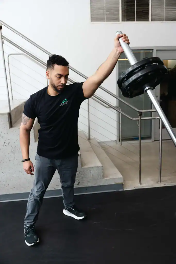 AG fitness trainer performs the landmine squat to press exercise.