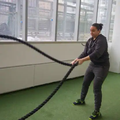 An Asphalt Green Fitness trainer performs the double battle ropes waves. 