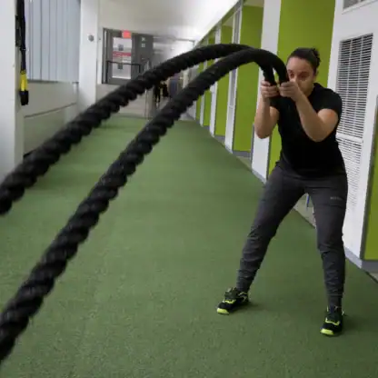 An Asphalt Green Fitness trainer performs the battle ropes slams. 