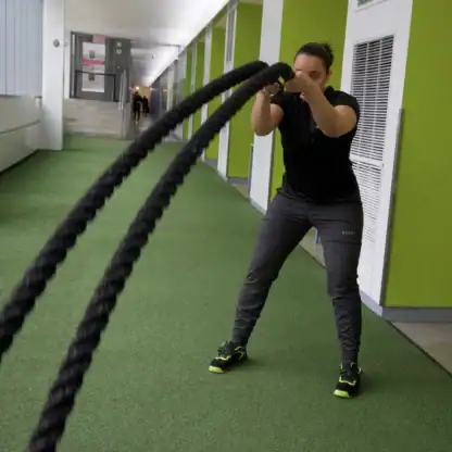 An Asphalt Green Fitness Trainer performs the battle ropes circles.