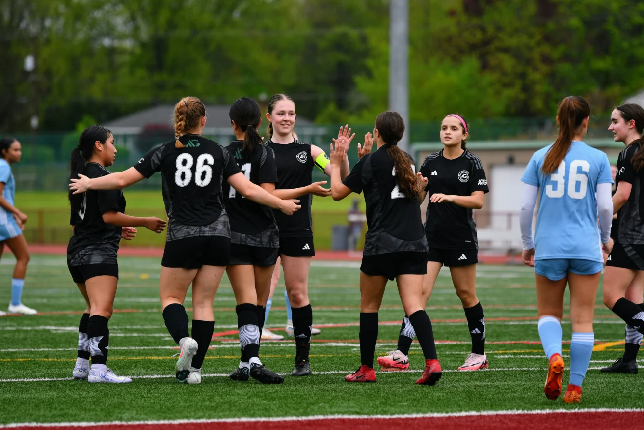 Asphalt Green Soccer Club team celebrates a goal.