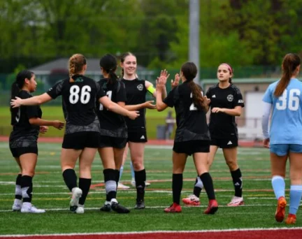 Asphalt Green Soccer Club team celebrates a goal.