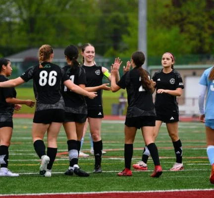 Asphalt Green Soccer Club team celebrates a goal.
